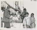 Image of Miriam and Polar Eskimo [Inuit] children grouped around recorder